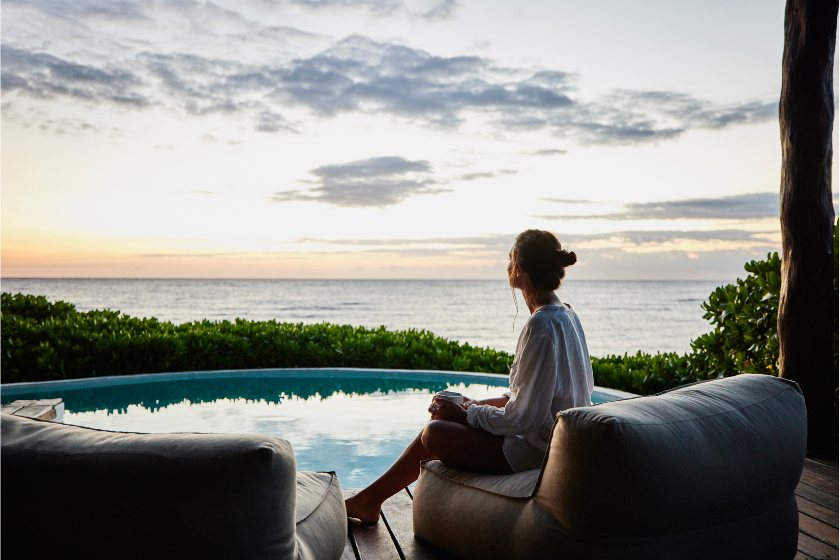 Femme voyageant seule sur une terrasse face à la mer